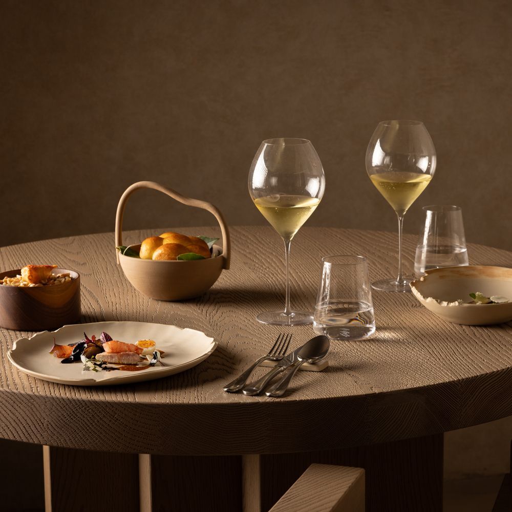 Mesa posta com design sofisticado e iluminação dramática no restaurante nomos ante.