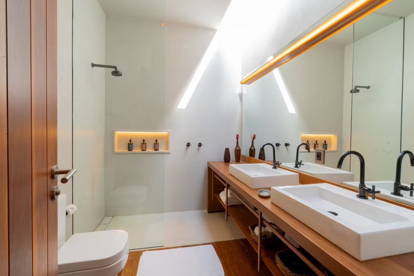 Detalhe de iluminação e nichos em banheiro moderno de casa de luxo para alugar em Itacaré, com acabamentos de alto padrão.