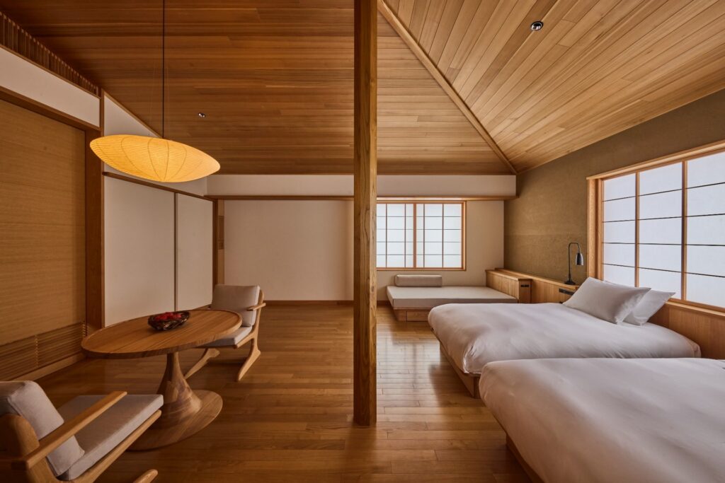 Suíte minimalista no Azuma Farm Koiwai com teto de madeira, telas shoji e design contemporâneo japonês.