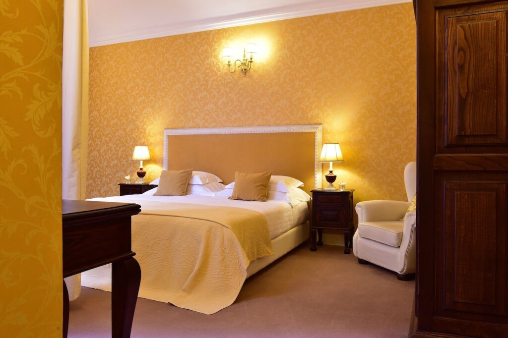 Quarto clássico com decoração dourada em uma das pousadas em portugal localizadas em Évora.