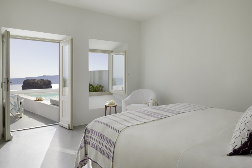 Suíte de luxo em hoteis boutique em santorini com terraço, piscina privativa e vista para o mar.