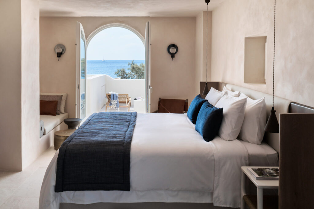 Suíte elegante com design mediterrâneo em hoteis boutique em santorini, vista para o mar.