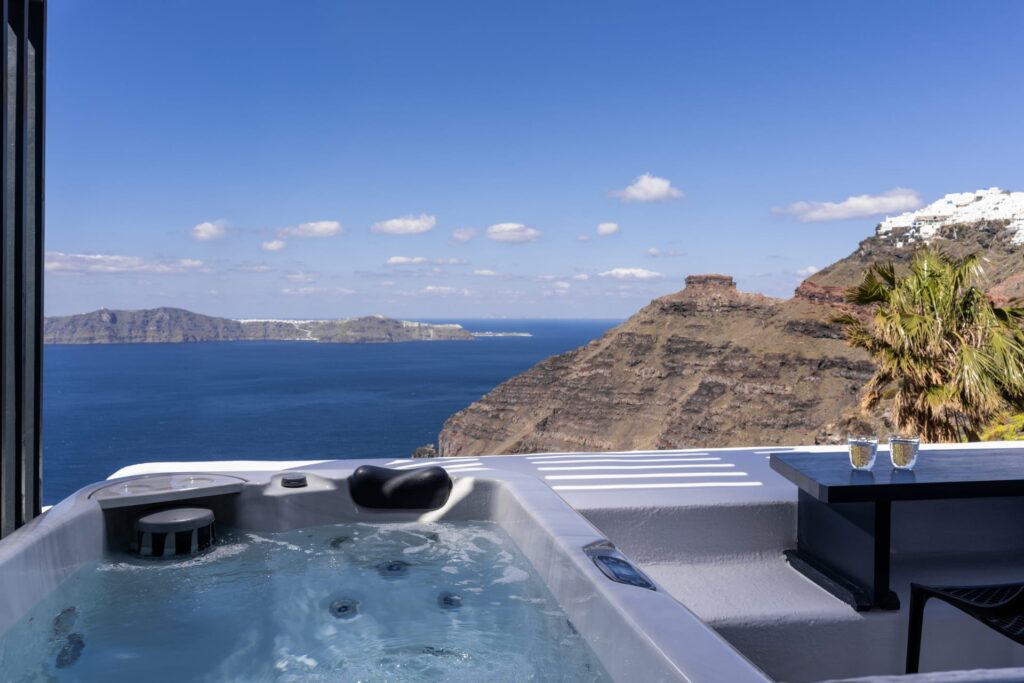 Jacuzzi externa com vista panorâmica para a caldeira em hoteis boutique em santorini.