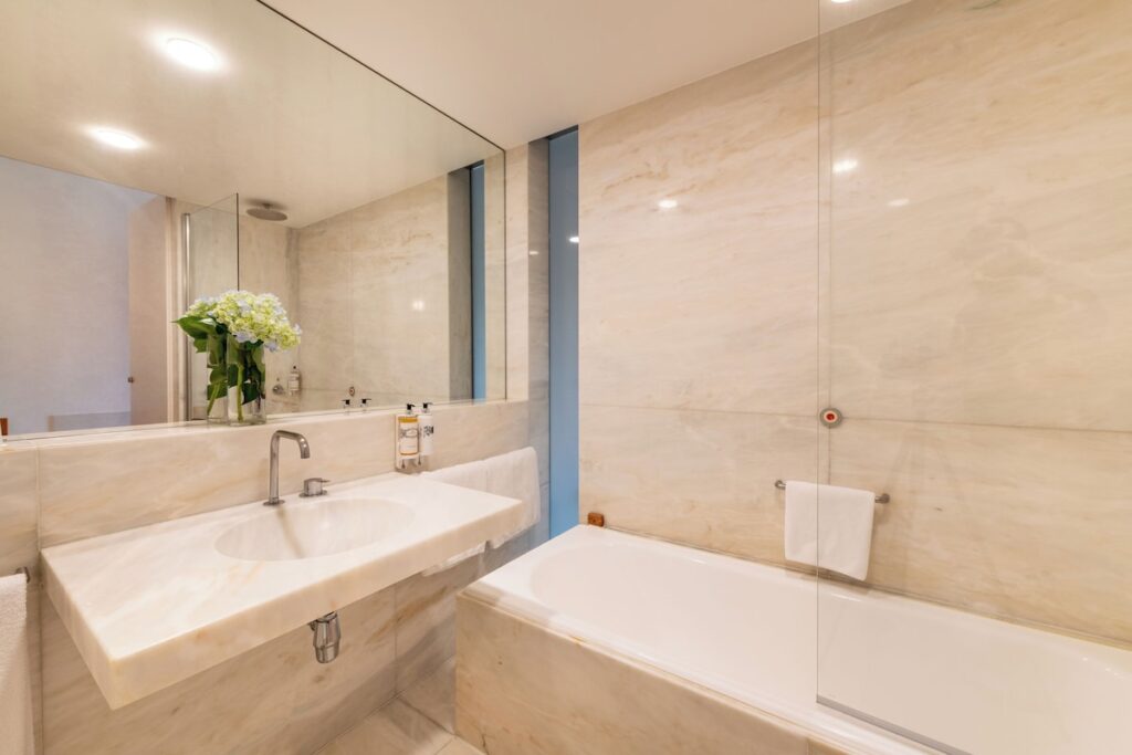Banheiro minimalista em mármore branco em uma das pousadas em portugal, com design assinado e linhas puras.