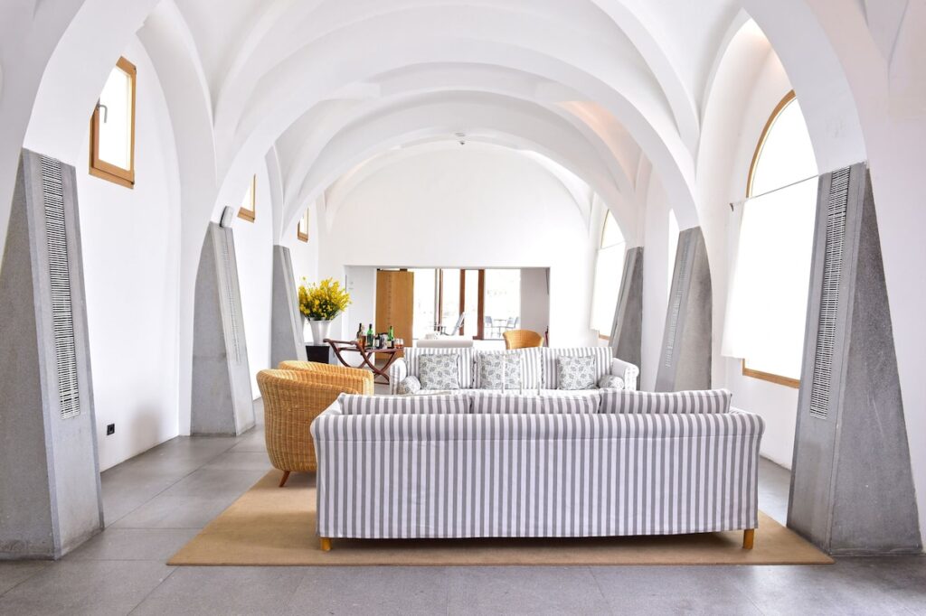 Sala de estar com teto abobadado branco, design de interiores moderno nas pousadas em portugal.