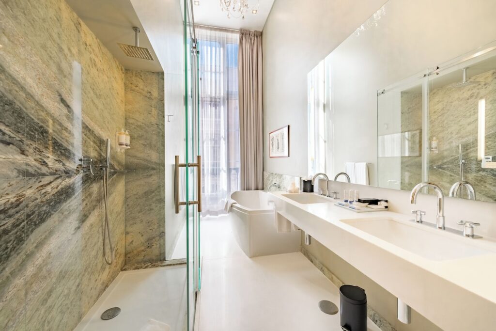 Banheiro de luxo em mármore com design moderno, conforto nas pousadas em portugal urbanas.