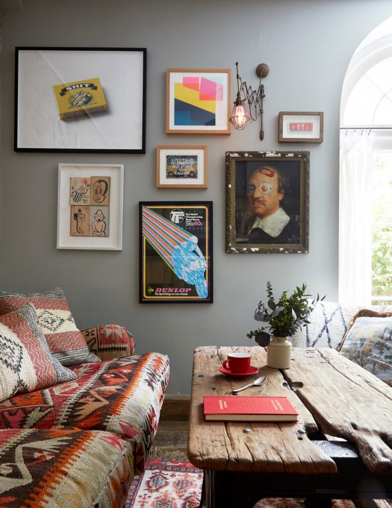 Parede com quadros e sofá étnico em hotéis boutique em londres com decoração eclética e artística.
