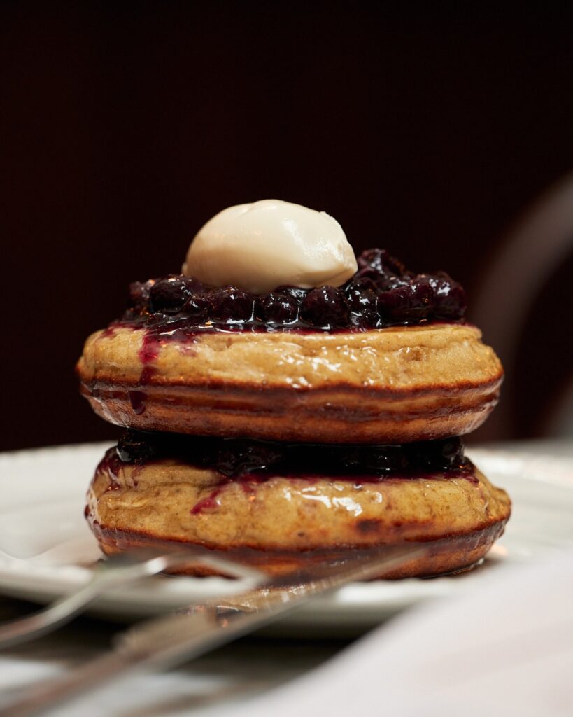 Café da manhã gourmet em hotéis boutique em londres com panquecas de mirtilo e creme.