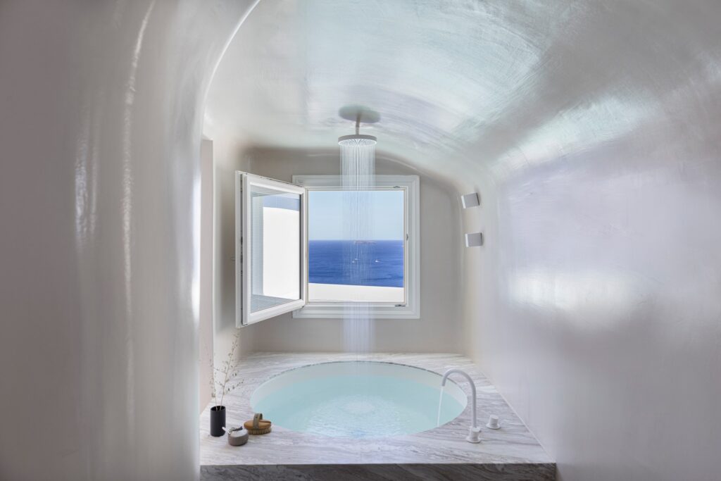 Banheira com vista panorâmica para o mar em hoteis boutique em santorini, design contemporâneo em branco.