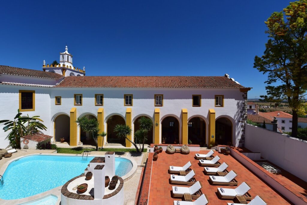 Piscina externa em pátio alentejano, cenário comum nas pousadas em portugal de luxo.