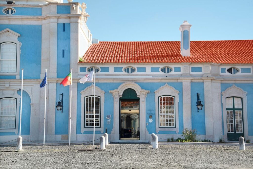 Fachada azul e branca de estilo palaciano, arquitetura icônica de uma das pousadas em portugal.