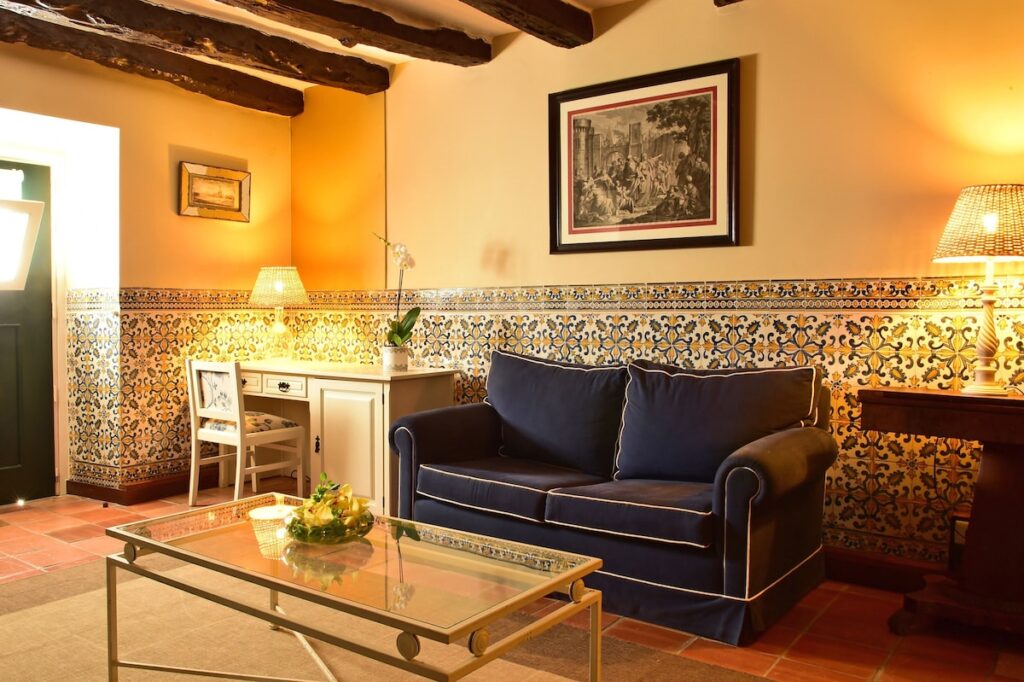 Sala de estar medieval com vigas de madeira e azulejos, charme das pousadas em portugal históricas.