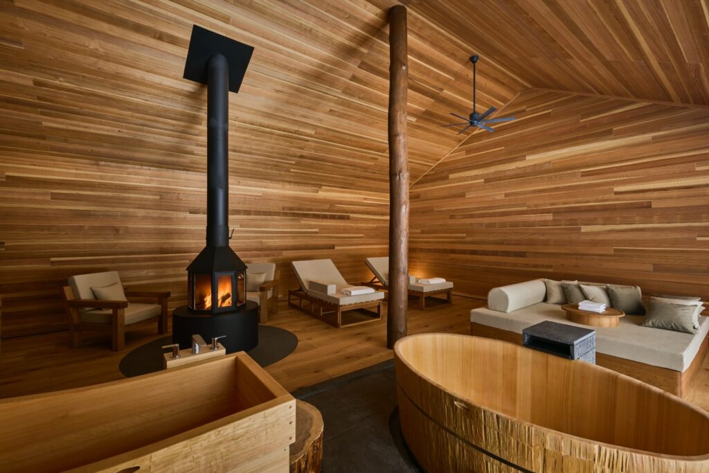 Sauna luxuosa em madeira no Azuma Farm Koiwai com lareira central e ofuros.