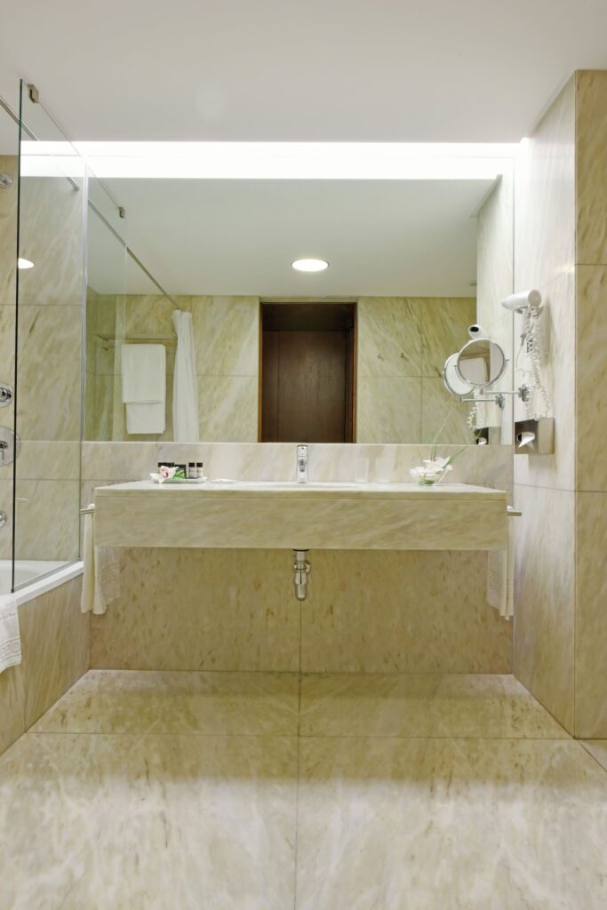 Banheiro contemporâneo em mármore bege, luxo e sobriedade em uma das pousadas em portugal.