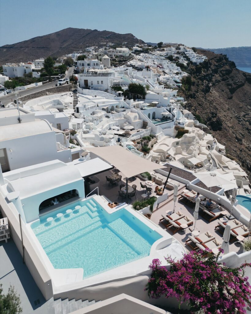 Vista aérea das piscinas e terraços de hoteis boutique em santorini, arquitetura típica de Oia.