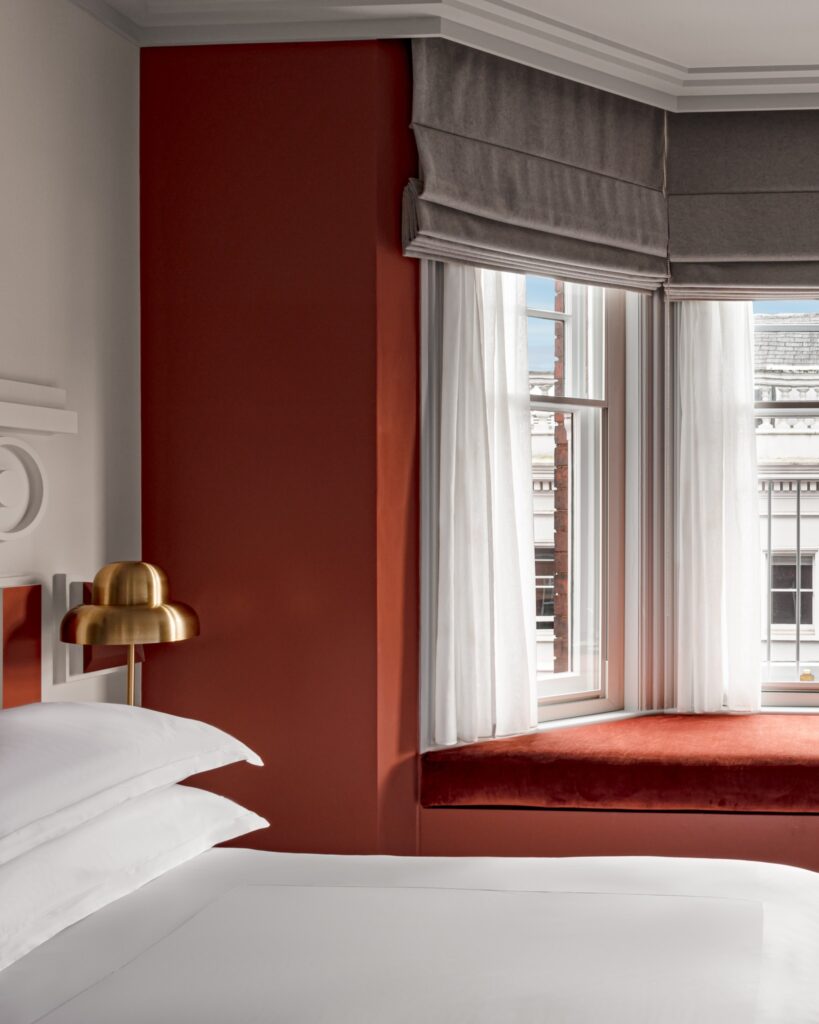 Quarto com parede terracota e bay window em hotéis boutique em londres.