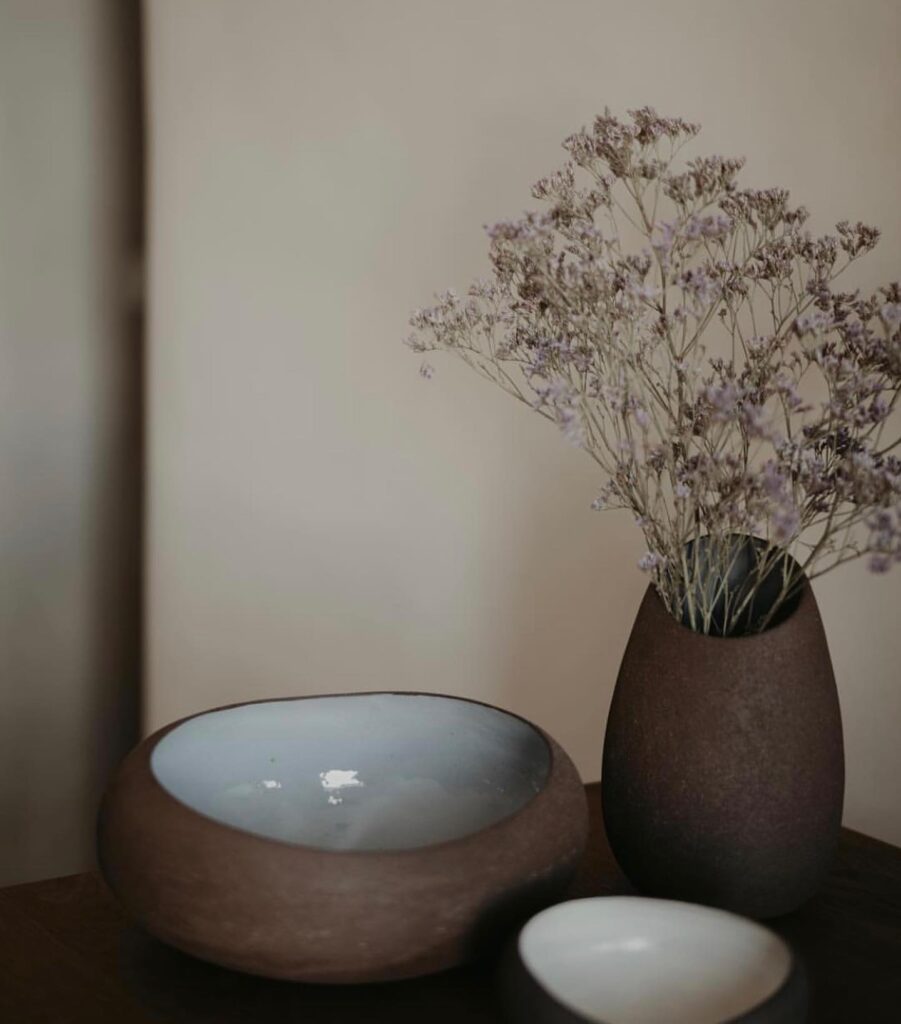 Detalhe de decoração artesanal com cerâmicas e flores secas, refletindo o estilo dos hotéis boutique em santorini.