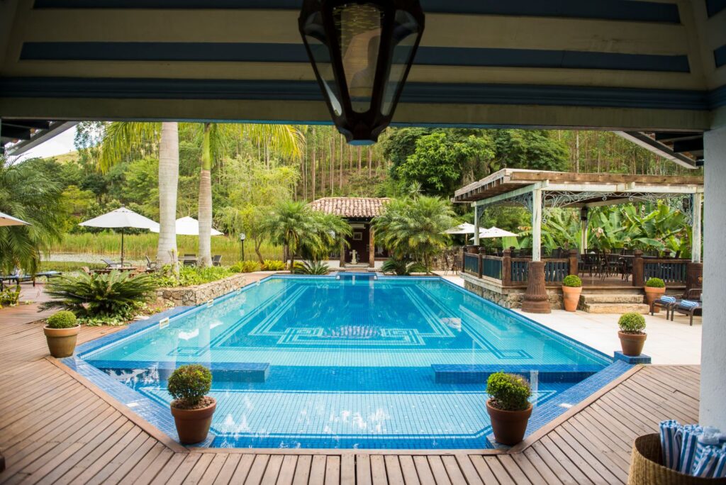 Piscina clássica com deck de madeira e bangalôs na Fazenda União, destaque em fazendas históricas para se hospedar.
