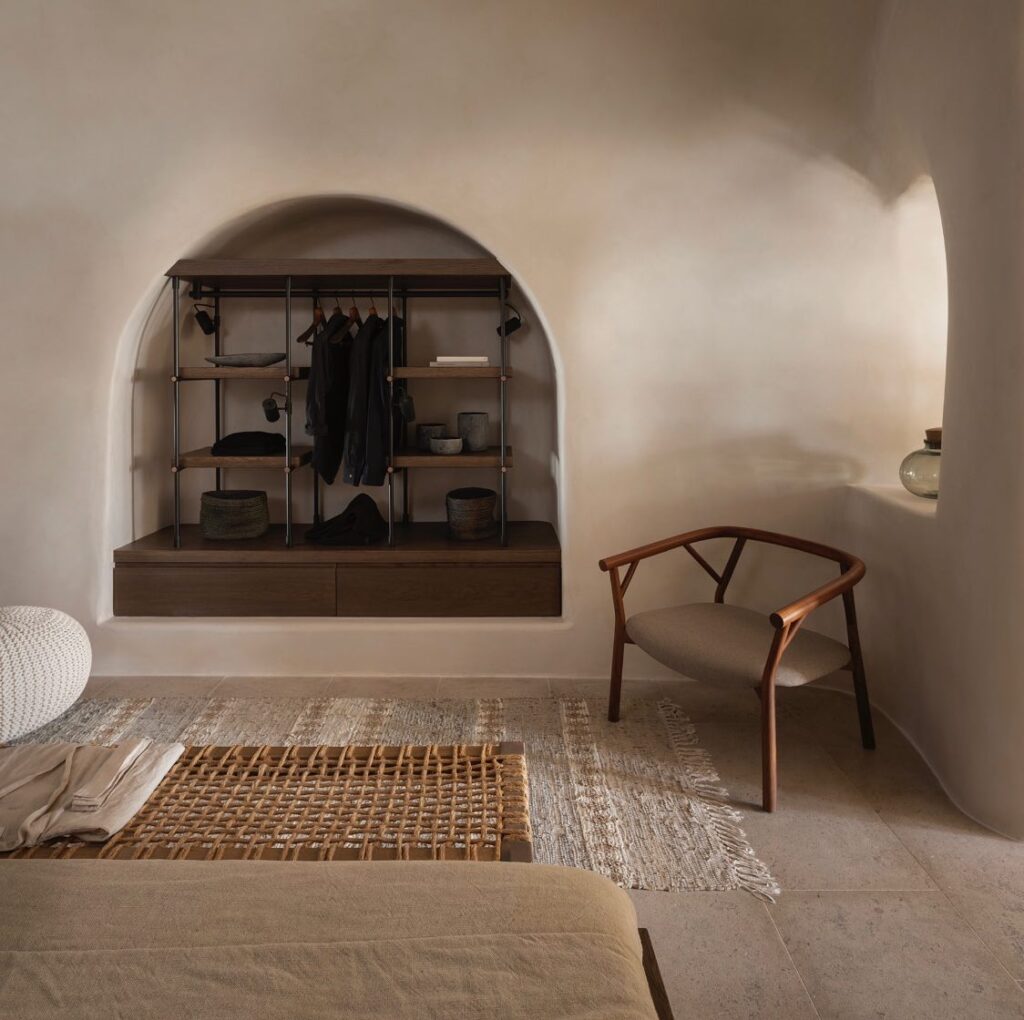 Interior de suíte com móveis de design e arquitetura orgânica, característica marcante dos hotéis boutique em santorini.