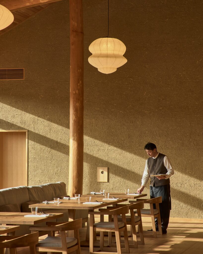 Restaurante do Azuma Farm Koiwai com paredes de terra e iluminação acolhedora.