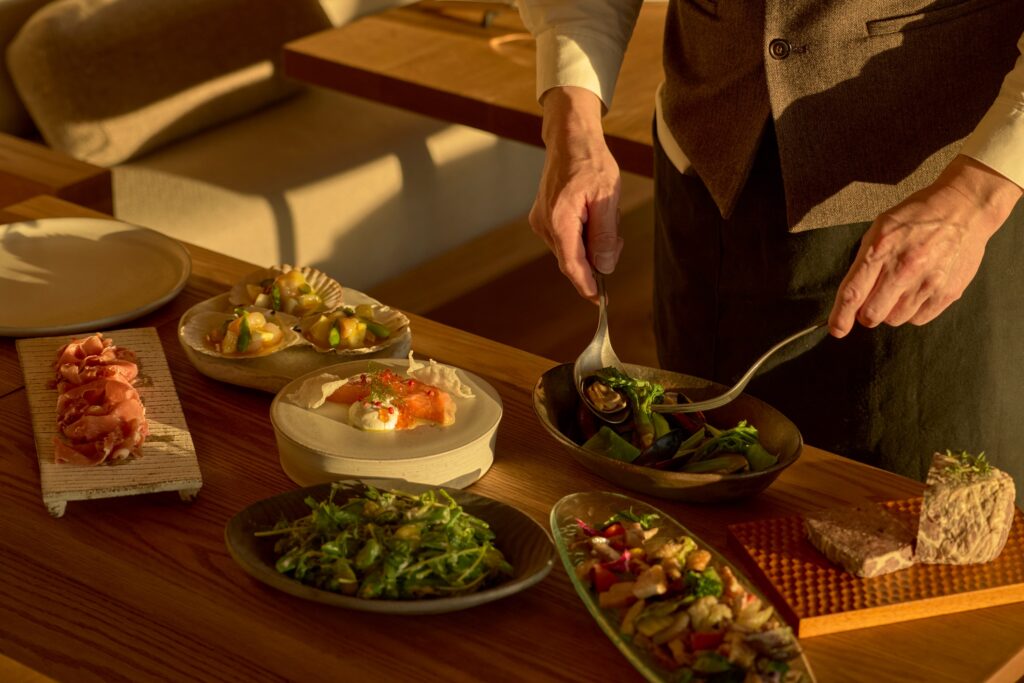 Pratos gourmet com ingredientes locais servidos em mesa de madeira no Azuma Farm Koiwai.