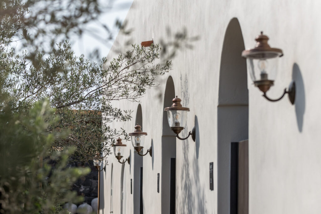 Fachada com janelas em arco e luminárias clássicas em hoteis boutique em santorini.