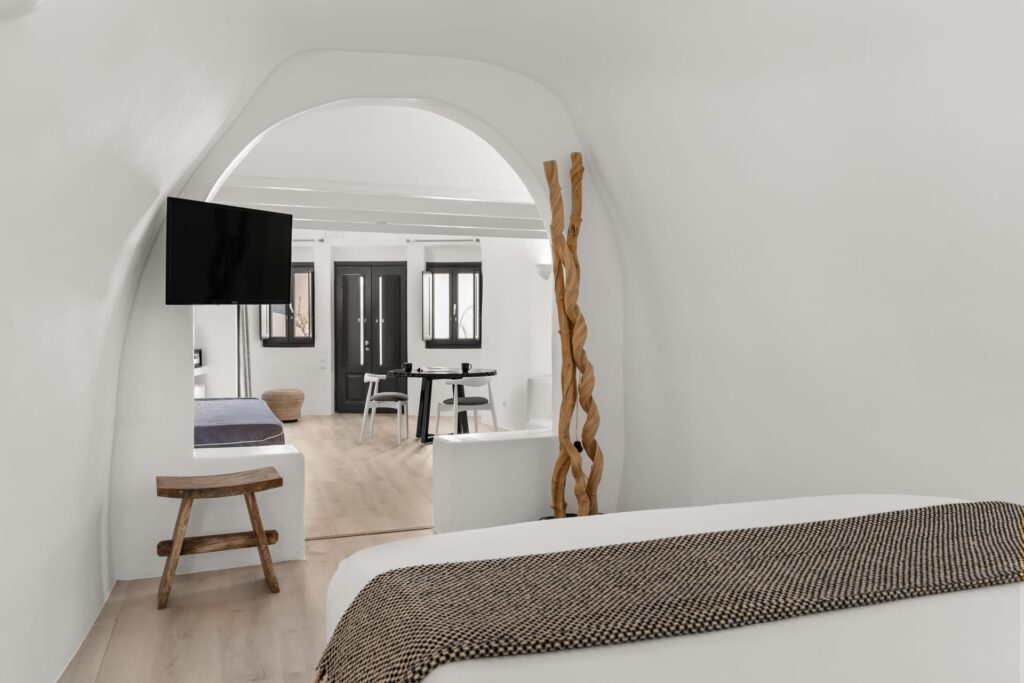 Suíte estilo caverna com design purista e elementos em madeira em hoteis boutique em santorini.