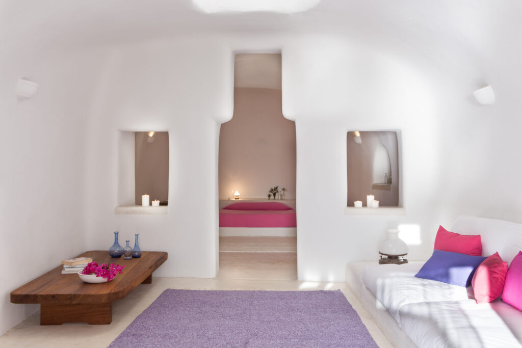 Design de interiores com cores vibrantes e formas orgânicas em hoteis boutique em santorini.
