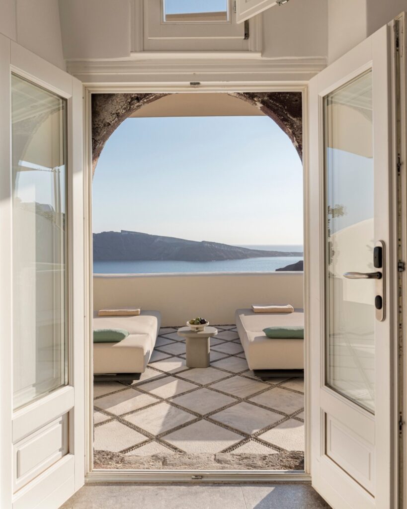 Terraço privativo com espreguiçadeiras e vista para o mar em hoteis boutique em santorini.