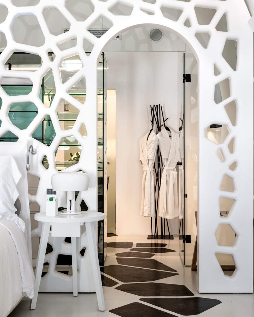 Painel vazado e piso orgânico em design de interiores de hoteis boutique em santorini.