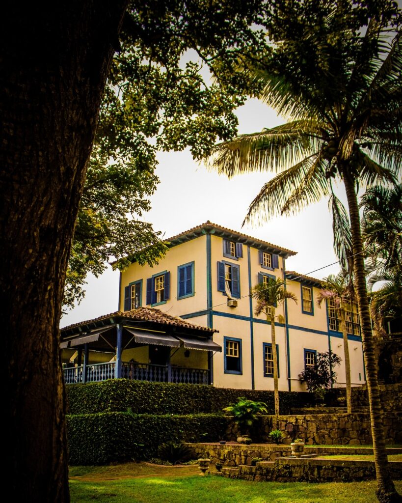 Fachada de casarão colonial com janelas azuis, ícone entre as fazendas históricas para se hospedar e vivenciar o passado.