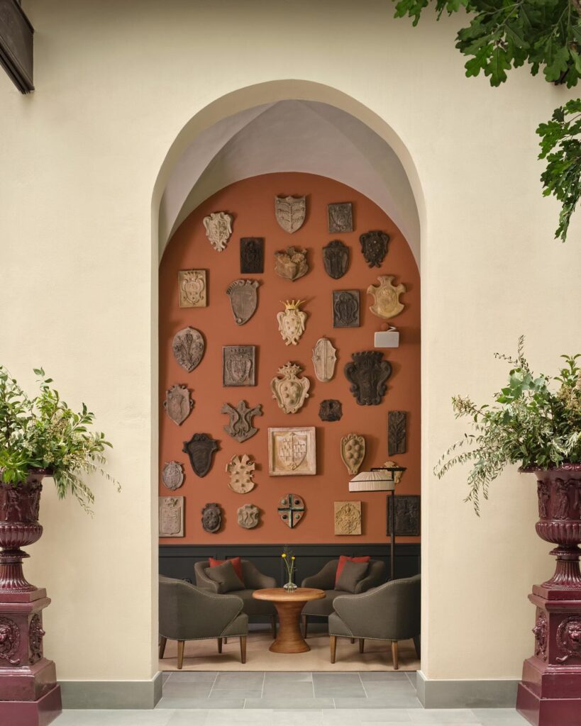Espaço de estar íntimo com parede terracota e decoração de brasões em hoteis boutique em santorini.