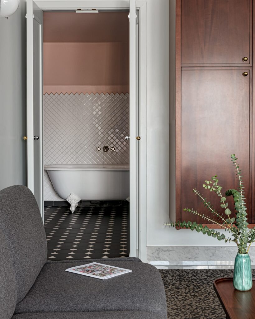 Banheiro de luxo com banheira vitoriana e teto rosa em hotéis boutique em londres.