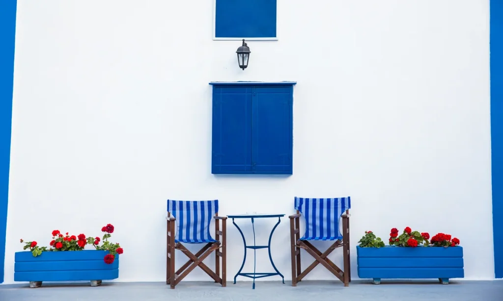 Fachada minimalista em azul e branco na Vila Firostefani, destacando a estética local na melhor época para visitar Santorini.