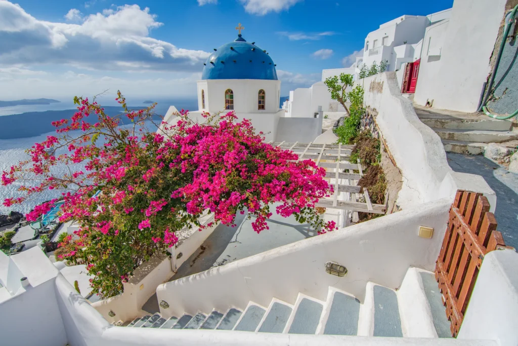 Vista icônica de Imerovigli com cúpula azul e buganvílias, ideal para fotografar na melhor época para visitar Santorini.