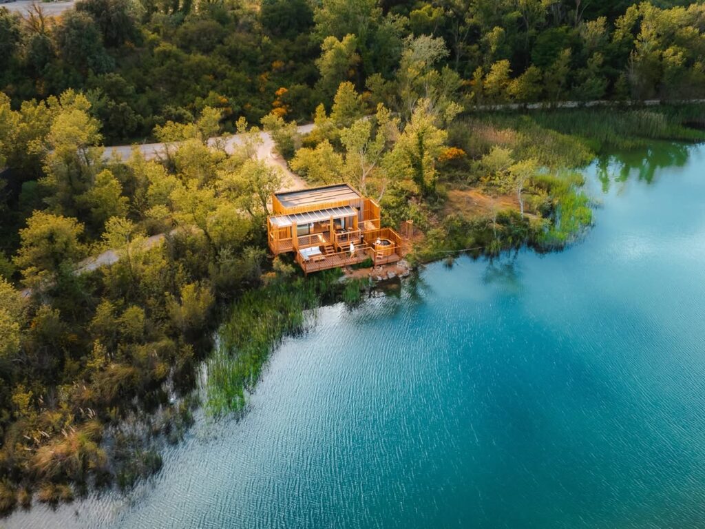 Vista aérea de cabana ecológica com ofurô nas Cabanes des Grands Cépages, destino sustentável de lua de mel na europa.
