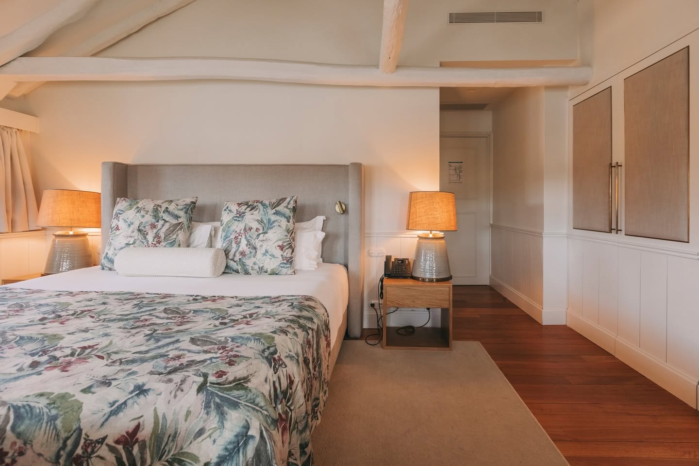 Suíte elegante em tons neutros e estampa botânica no Gran Cruz House, uma referência de hotéis boutique no Porto com design acolhedor.