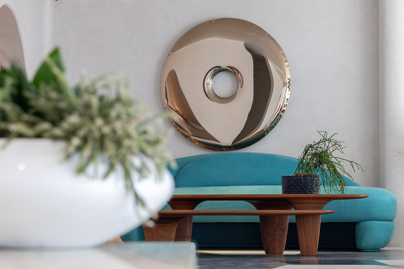 Sofá turquesa orgânico de Loro Piana e mesa de centro de madeira no lobby do Nammos Hotel, resort em Mykonos de estilo minimalista.