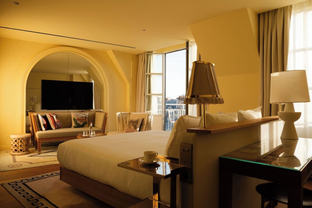 Quarto elegante do 9Hotel Confidential, um dos mais charmosos hoteis boutique em paris, com decoração em tons amarelos, móveis de design e varanda.