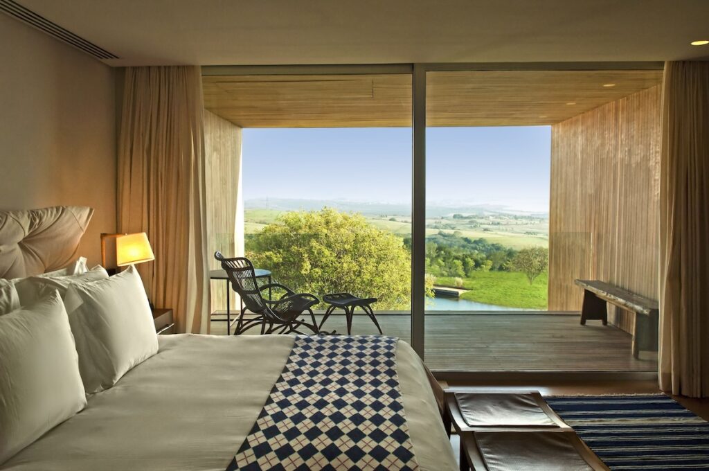 Quarto com varanda integrada e vista para o lago no Hotel Fasano Boa Vista de Porto Feliz, um dos mais elegantes hoteis romanticos em são paulo.
