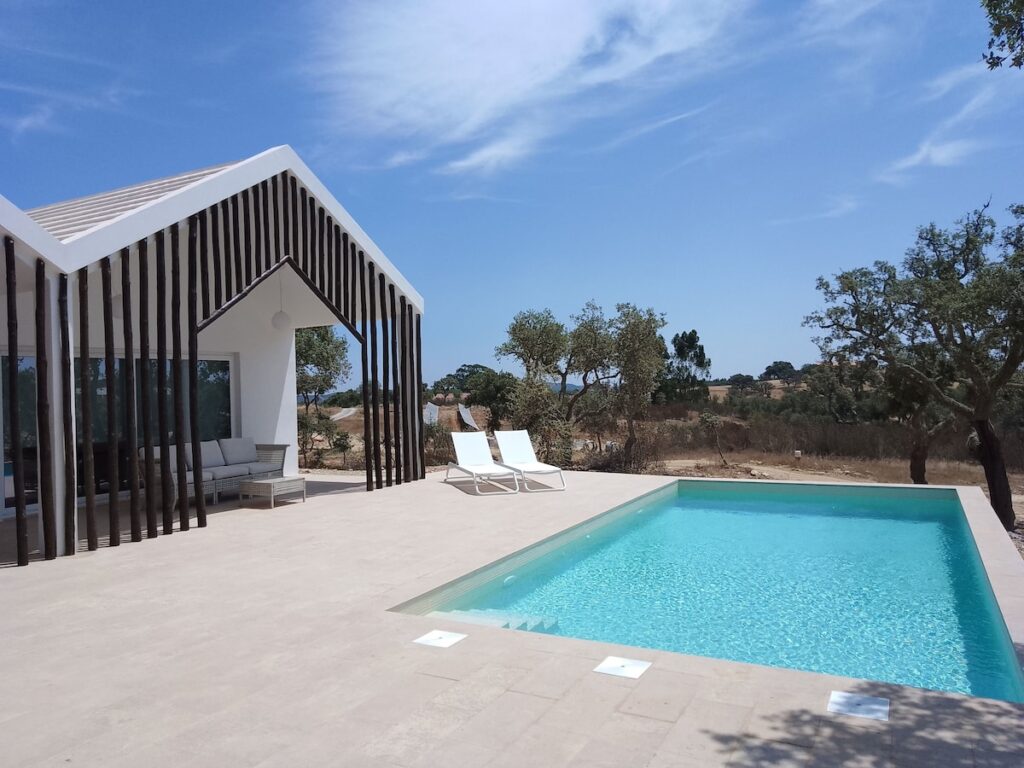 Piscina retangular integrada a edifício moderno de eucalipto no Sobreiras Alentejo, refúgio de lua de mel na europa.