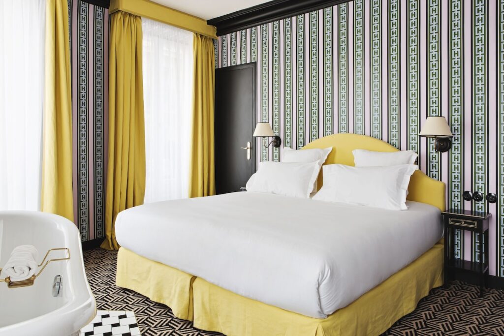 Quarto com decoração maximalista em tons de rosa, verde e amarelo mostarda no Hôtel Les Deux Gares, um dos mais charmosos hotéis boutique em paris.