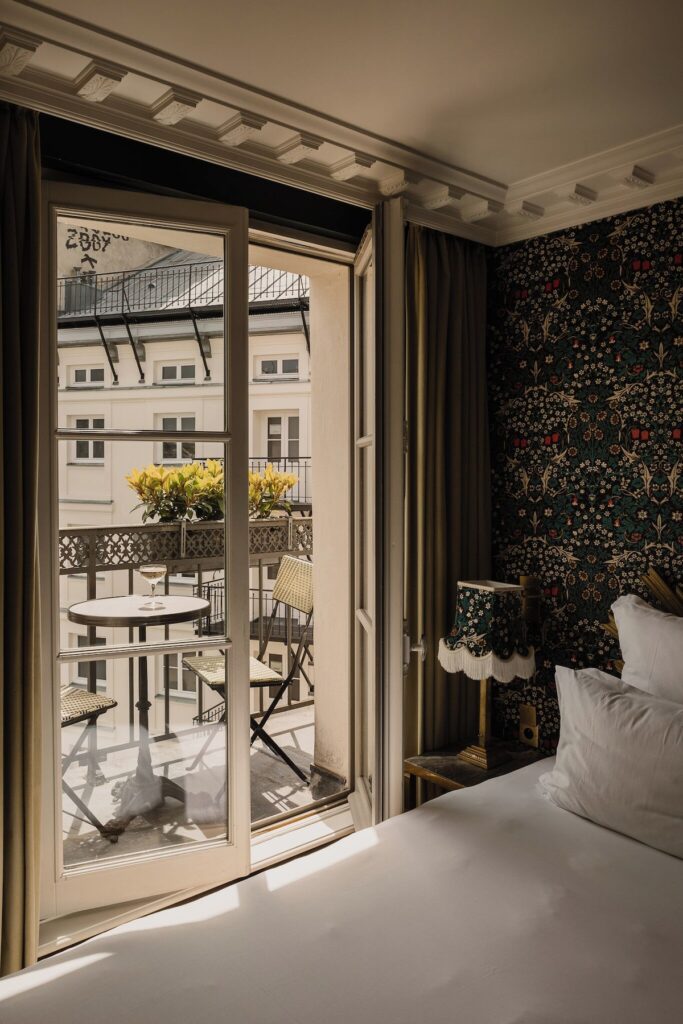 Quarto clássico do Hôtel Providence -Canal Saint -Martin, destaque na lista de hoteis boutique em paris, com varanda parisiense e cortinas de veludo.