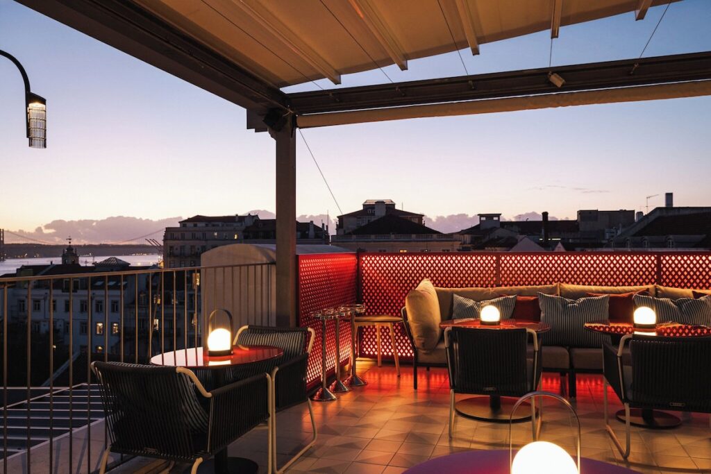 Rooftop BAHR com mesas iluminadas e vista para o Tejo no Bairro Alto Hotel. Esse hotel boutique vale a pena!