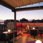 Rooftop BAHR com mesas iluminadas e vista para o Tejo no Bairro Alto Hotel. Esse hotel boutique vale a pena!