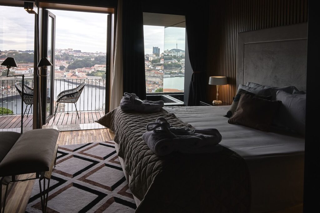 Suíte master com varanda panorâmica e painel ripado no Torel Avantgarde. Hospedar-se em um hotel boutique vale a pena.