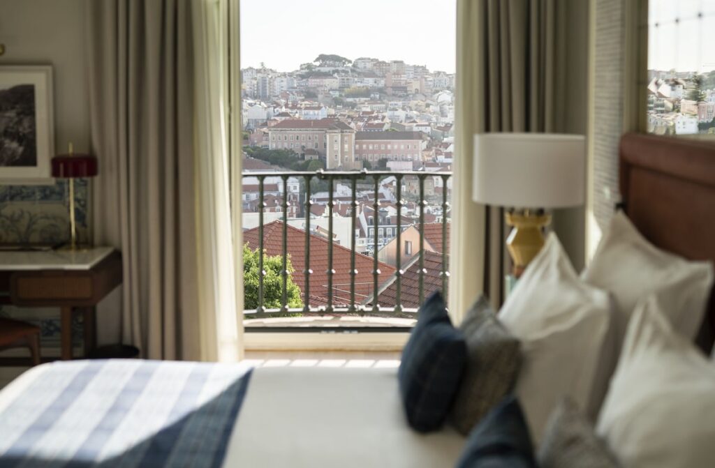 Vista dos telhados históricos a partir da suíte do Ludovice Wine Experience, um destaque entre hoteis boutique em lisboa. Quarto aconchegante com sacada.