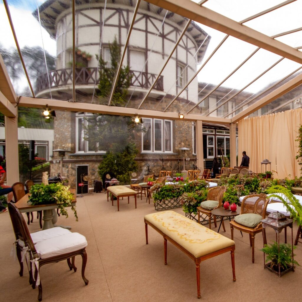 Lounge de recepção decorado sob tenda com a torre histórica de um dos principais hotéis românticos em são paulo ao fundo.