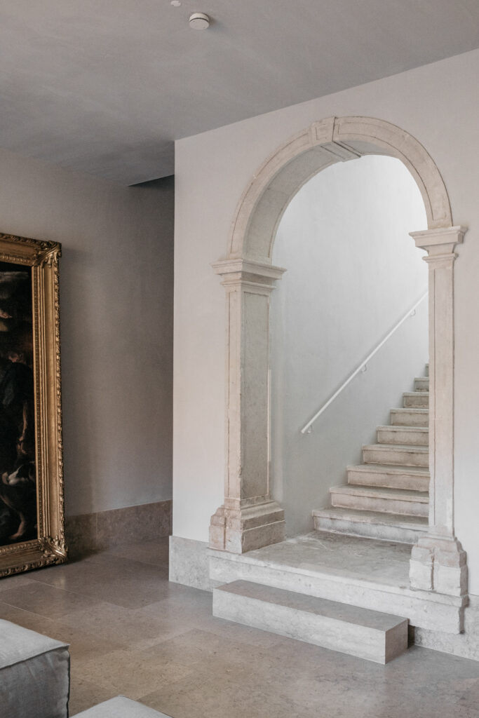 Portal de arco de pedra e escadaria minimalista no Santa Clara 1728, destaque de arquitetura contemporânea nos hoteis boutique em lisboa.