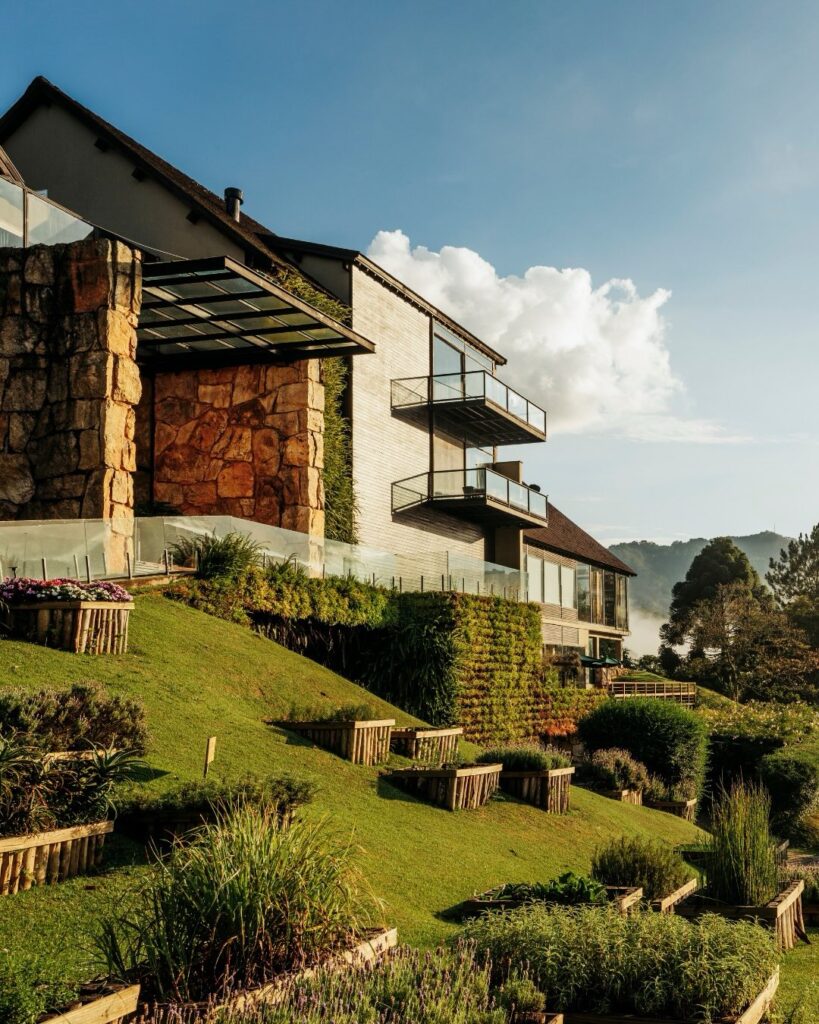 Fachada monumental de pedra e ripas do hotel six senses botanique, referência em hoteis romanticos em são paulo na serra.